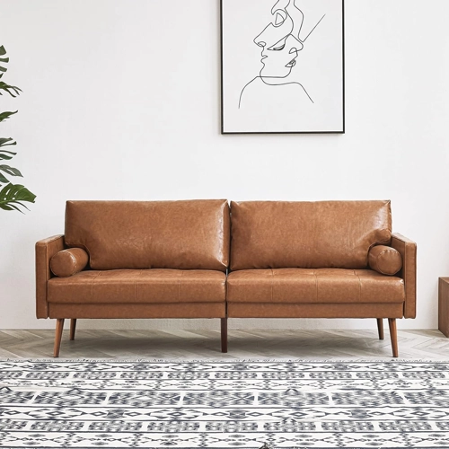 A modern brown leather sofa with two seat cushions and matching cylindrical bolster pillows on each armrest.