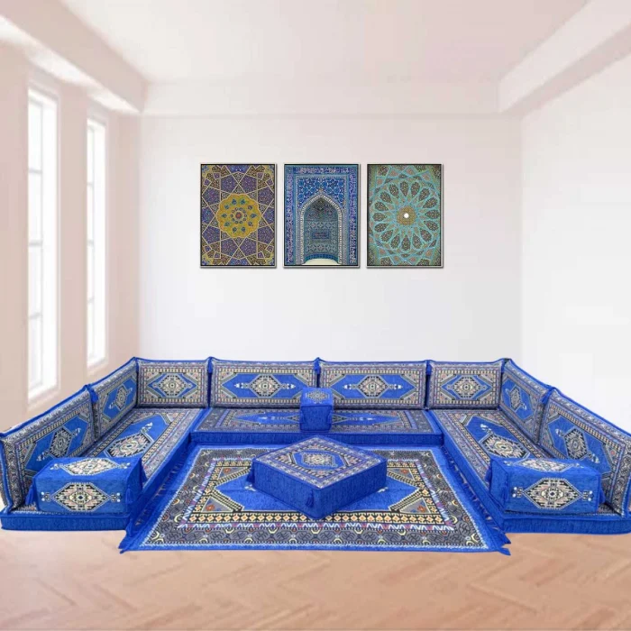 A beautifully arranged blue and gold majlis sofa, featuring intricately patterned floor cushions and a matching rug.