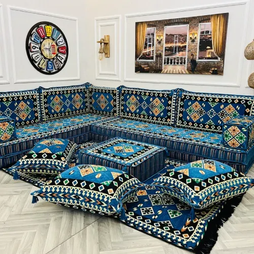 A beautifully arranged blue and gold majlis sofa set with intricate patterns and floor cushions.