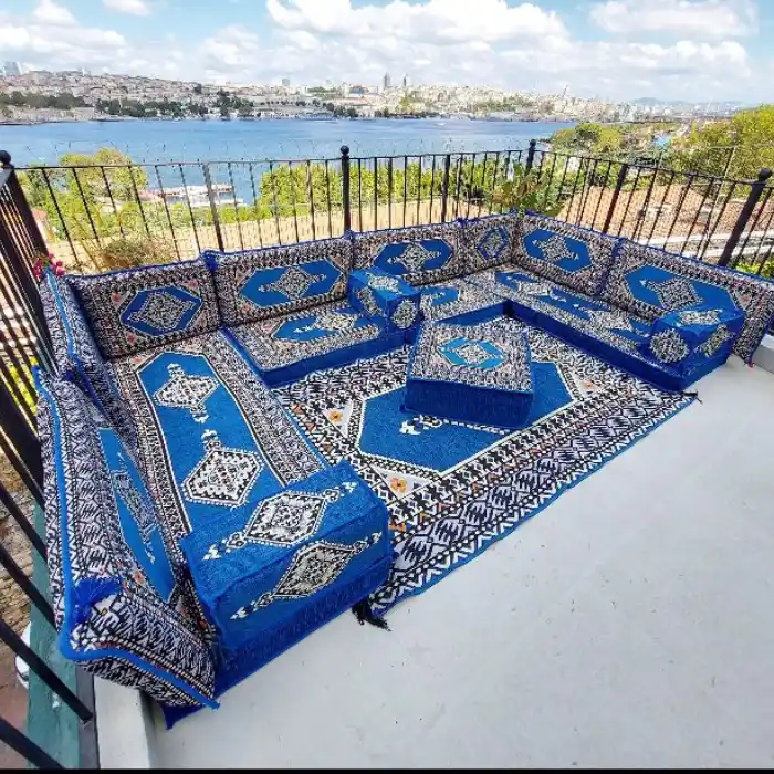 A set of majlis sofa with rug at outdoor space with beautiful sea view background