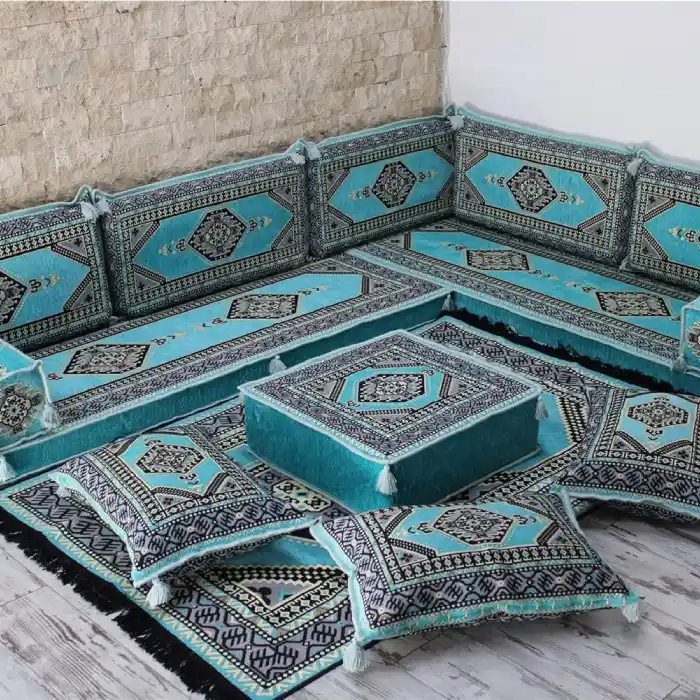 An L-shaped majlis sofa set with plush turquoise cushions and black geometric patterned detailing