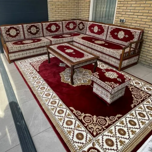 Comfortable and elegant majlis sofa seating area with patterned cushions, a central table, and a decorative rug on a patio.