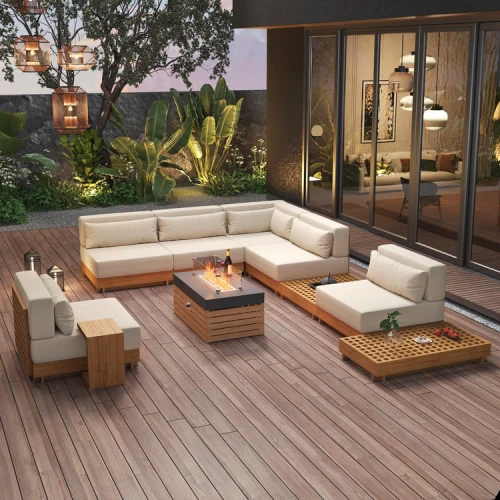 A teak outdoor sofa set with plush cushions arranged around a glass-topped fire pit on a wooden deck, creating a stylish outdoor living space.